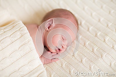 Tiny newborn baby on a soft knitted blanket Stock Photo