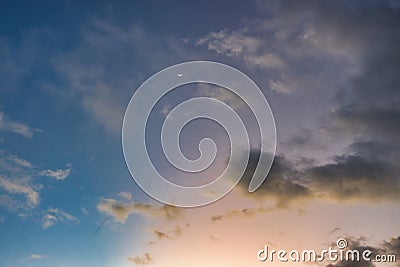 Tiny sliver moon in a sky just after sunset. Stock Photo