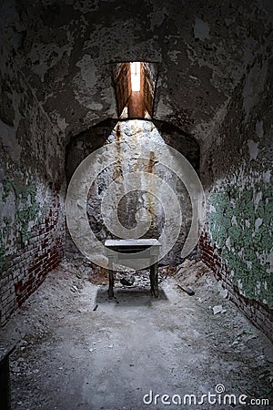 Tiny stool in an abandoned prison cell Stock Photo