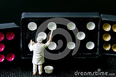 Tiny toy painter white on domino. Stock Photo