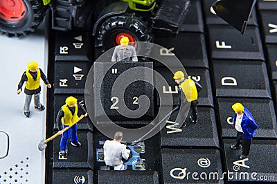 Tiny toys team of engineers repairing keyboard computer laptop.Computer equipment.Computer repair concept Stock Photo