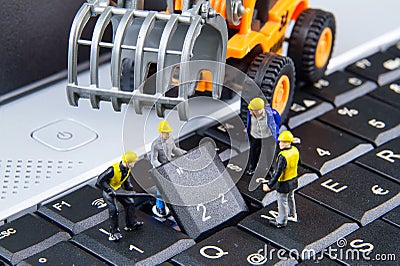 Tiny toys team of engineers repairing keyboard computer laptop.Computer equipment.Computer repair concept Stock Photo