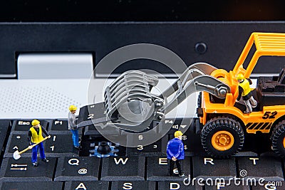 Tiny toys team of engineers repairing keyboard computer laptop.Computer equipment.Computer repair concept Stock Photo