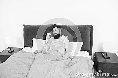 Tips for waking up early. Man bearded sleepy face bed with alarm clock in bed. What terrible noise. Turn off that Stock Photo