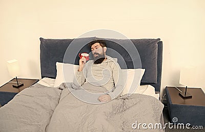 Tips for waking up early. Man bearded sleepy face bed with alarm clock in bed. What terrible noise. Turn off that Stock Photo