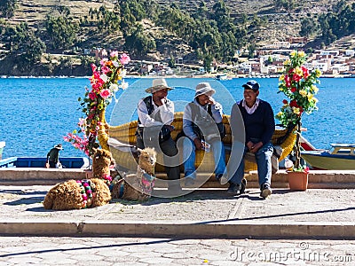 Tiquina, Bolivia - December 7, 2011: Three men sitting on a bench Editorial Stock Photo