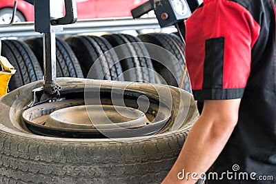 Tire change closeup, Mechanic is changing car tire engineer balancing car wheel on balancer in workshop Stock Photo