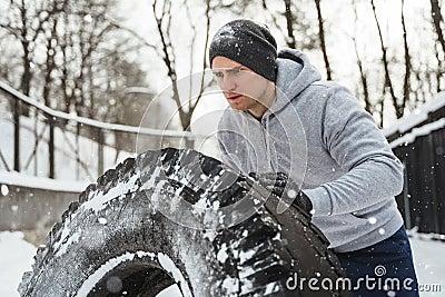 Strong sportsman during his cross training workout during snowy and cold winter day. Stock Photo