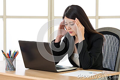 Tired asia businesswoman with headache in the office Stock Photo