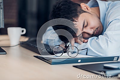 Tired asian businessman sleep on working desk table in office.working hard and late.burn out syndrome Stock Photo