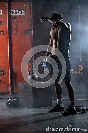 Tired athlete topless wipes the sweat from his Stock Photo