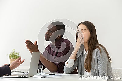 Tired bored businesswoman yawning at boring meeting with diverse Stock Photo