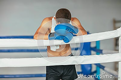 Tired boxer resting in boxing ring Stock Photo