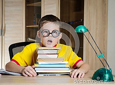 Tired Boy Wearing Funny Glasses Doing Homework. Child With Learning Difficulties. Boy Having Problems With His Homework. Education Stock Photo