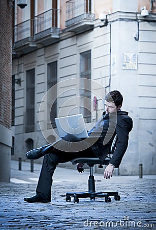 Tired Business Man sitting on Office Chair on Street sleeping Stock Photo