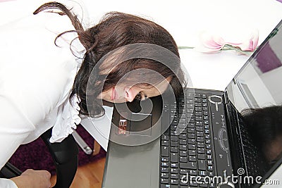Tired business woman fell asleep next to a laptop Stock Photo