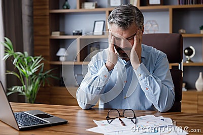 Tired businessman after exhausting paperwork feeling eye strain. Head ache, bad vision, chronic fatigue and eyestrain Stock Photo