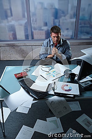 Tired businessman with papers all around Stock Photo