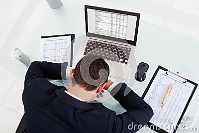 Tired businessman sleeping while calculating expenses in office Stock Photo