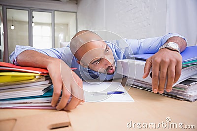 Tired businessman with stack of files on desk Stock Photo