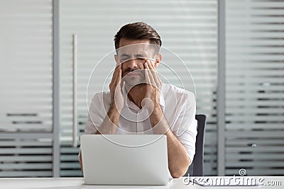 Exhausted male employee feel fatigue suffering from headache Stock Photo