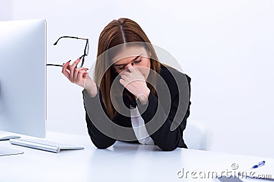 Tired businesswoman rubbing her eyes Stock Photo