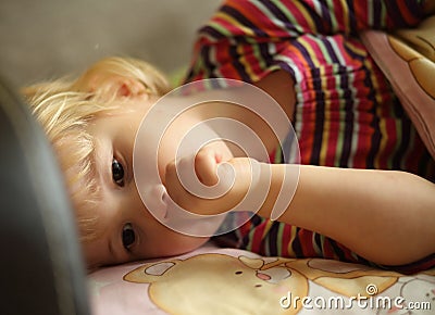 Tired child on bed suck finger Stock Photo