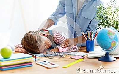 Tired child girl fell asleep when she did her homework at home Stock Photo