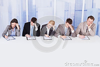 Tired corporate personnel officers at table Stock Photo