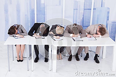 Tired corporate personnel officers at table Stock Photo
