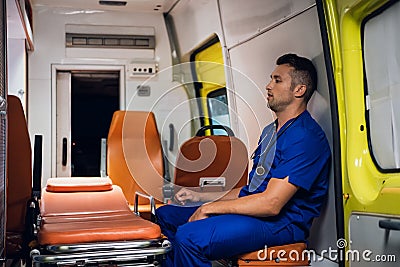 Tired corpsman sits inside the ambulance car Stock Photo