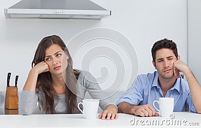 Tired couple sitting at the table with a cup of coffee Stock Photo