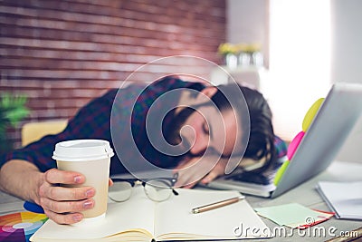 Tired creative editor holding disposable cup Stock Photo