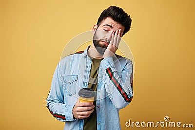 Tired exhausted student with sleepy expression, covers face with palm Stock Photo