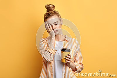 Tired fair-haired sleepy woman holds a cup of coffee Stock Photo