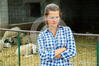 Tired farm worker stands near the corral Stock Photo