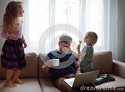 Tired father with his two kids during quarantine. Stay at home concept. Online working and household at the same time while Stock Photo