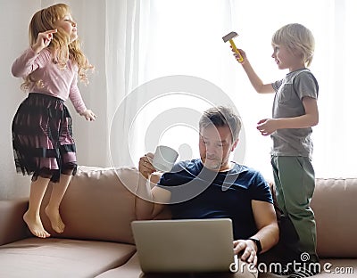 Tired father with his two kids during quarantine. Stay at home concept. Online working and household at the same time while Stock Photo