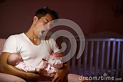 Tired Father At Home Cuddling Twin Baby Daughters In Nursery Stock Photo