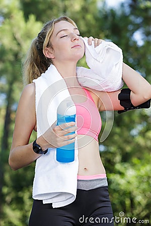 Tired female jogger using towel Stock Photo