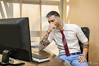 Tired or frustrated office worker at computer Stock Photo