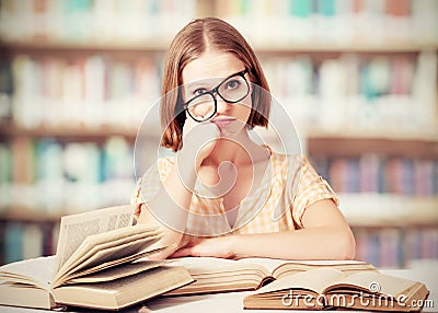 Tired funny girl student with glasses reading books Stock Photo