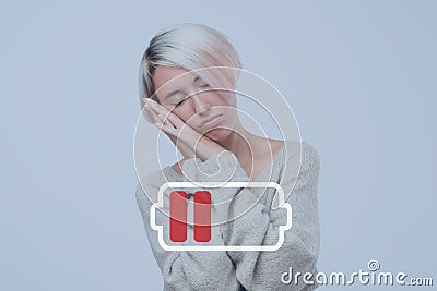 tired girl suffering from insomnia. Low life energy. Need to take a break. Sign of battery in front Stock Photo