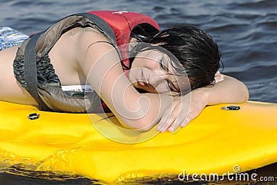 Tired but happy girl after training lies on surfin Stock Photo