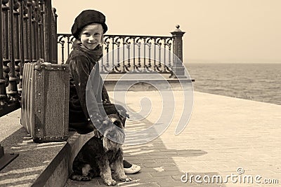 Tired little girl sitting on the road with a dog Stock Photo