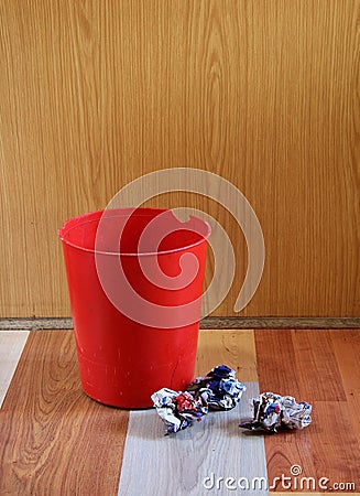 Tired looking red dustbin Stock Photo