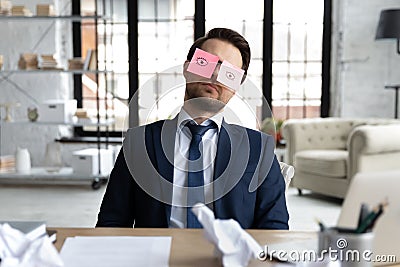 Tired male employee fall asleep at workplace Stock Photo