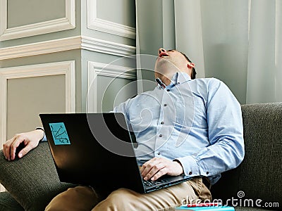 Tired man with chronic fatigue syndrome cfs sleeps with laptop. Stock Photo