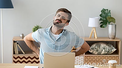 Tired man feeling backache after sedentary computer work Stock Photo
