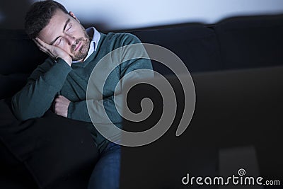 Tired man in front of television Stock Photo